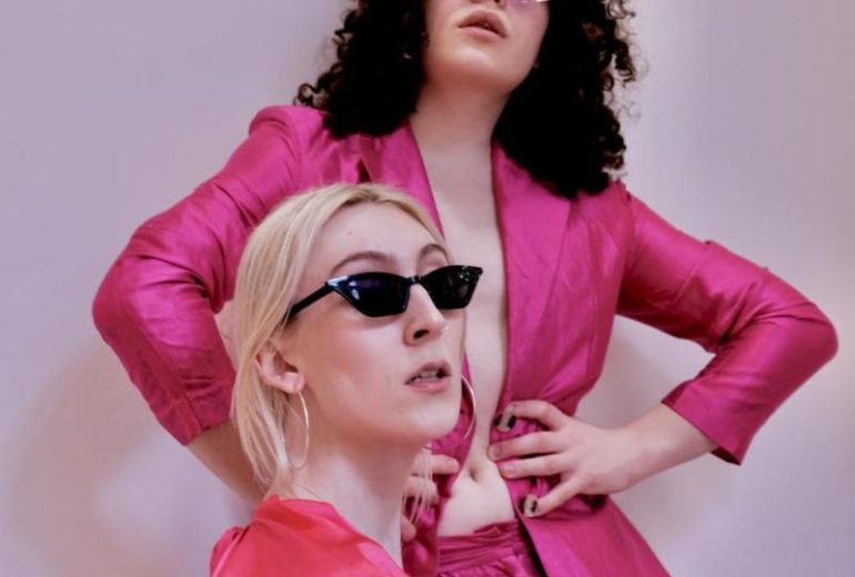 2 glorious pink clad figures in a photoshoot