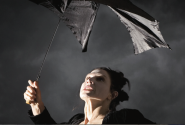 woman with broken umbrella in a storm